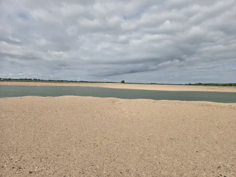 Wide sandy flats and open water at the Dyer Sandpit, an off-channel nesting habitat site.